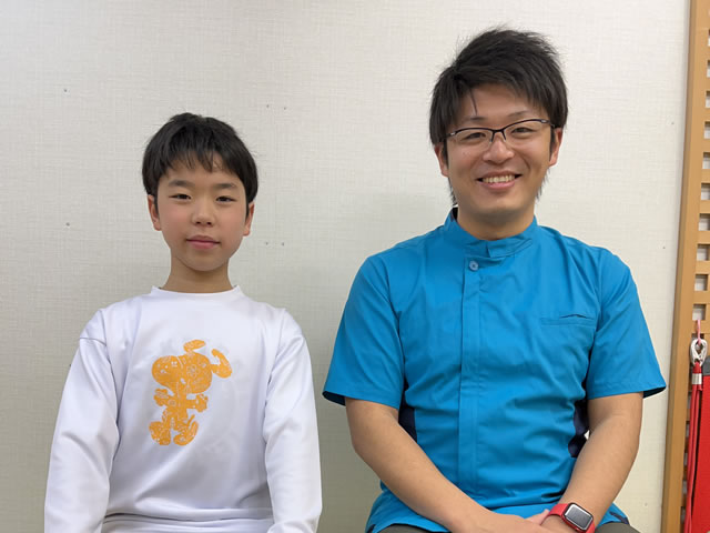 名東区の足腰ラボ接骨院に通いバスケ中のすねの痛みが練習でいっぱい動いても痛くなくなったお客様と写真撮影する藤田院長