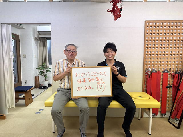 名東区の足腰ラボ接骨院で腰痛、背中痛が治ったお客様と写真撮影する藤田院長