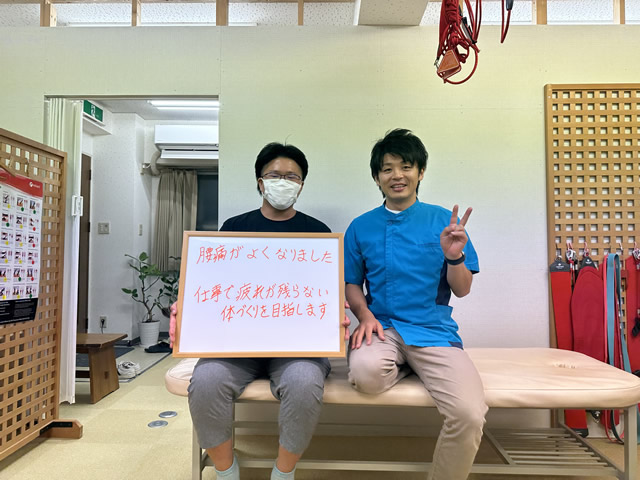 名東区の足腰ラボ接骨院で腰痛が良くなり、仕事で疲れがたまらない体づくり頑張るお客様と写真撮影する藤田院長